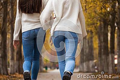 Two girlfriends in a white woolen sweater and blue jeans Stock Photo