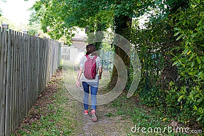 Back view of woman in pathway park path walking in Saint medard en jalles France Stock Photo