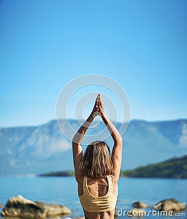 Back view woman practices yoga at nature with beutiful mountains Stock Photo