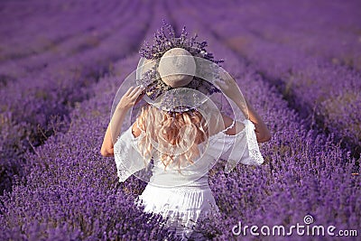 Back view of Young blond woman in lavender field. Happy carefree Stock Photo