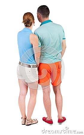 Back view of young embracing couple in shorts hug and look. Stock Photo