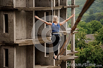 Back view of fearless woman walking on a slackline Stock Photo