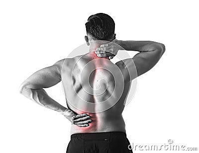 Back view of young man with muscular body holding his neck and low back suffering spinal pain Stock Photo