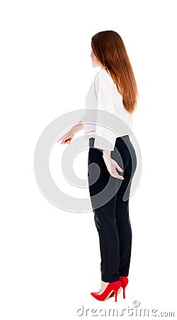 Back view of young redhead business woman pointing at wall. Stock Photo