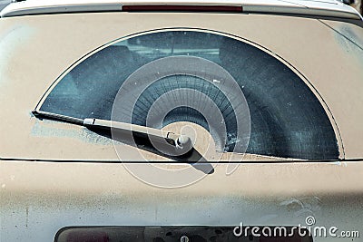 Back window covered with a dust layer of a dirty gray car. Stock Photo