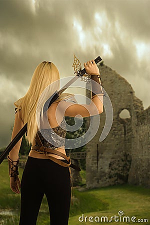 Back of woman warrior drawing her sword Stock Photo