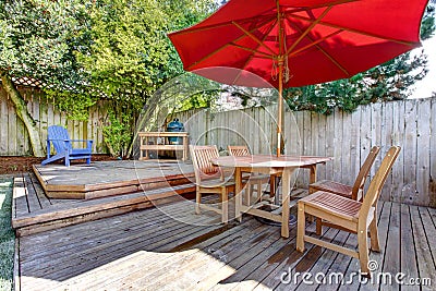 Back yard large deck with red umbrella and chairs. Stock Photo