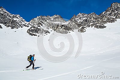 Backcountry skiing in the Talkeetna Mountains of Alaska. Skier moving uphill under large cliff bands in Hatcher Pass area Stock Photo