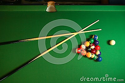 Backdrop of pyramid of pool balls and billiard cues Stock Photo