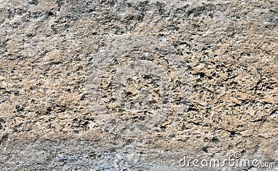 Pale gray and light brown rough weathered stone block with holes from an old wall Stock Photo