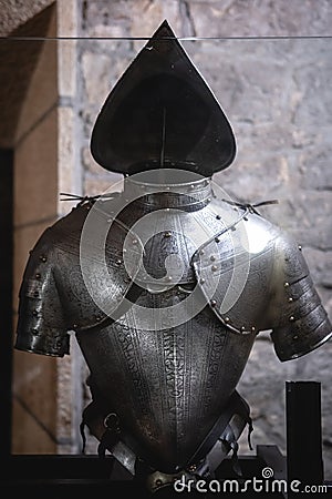 Background with armour of the medieval knight. Metal protection of the soldier. Steel Plate. Rivets and engraving, dark light Stock Photo
