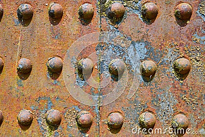 Background asset colorful rivets on industry iron metal corroding with flaking yellow rusty decay Stock Photo