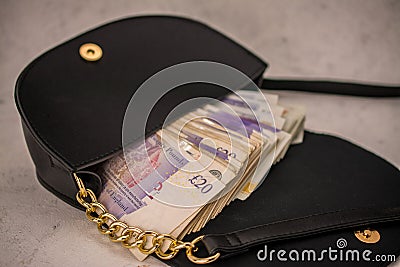 hand bag ,purse with UK pounds banknotes background. Money of United Kingdom Editorial Stock Photo