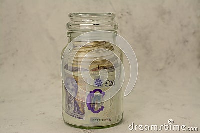 jar full of with UK pounds banknotes background. Money of United Kingdom Editorial Stock Photo