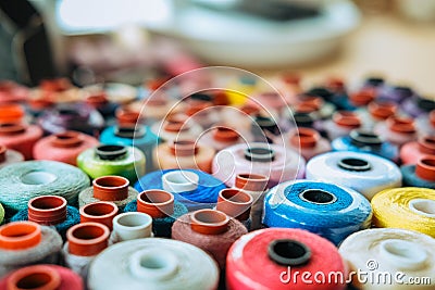 Background banner Side view many multicolored spools of thread that lie in box Stock Photo