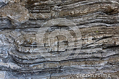 Background on the basis of the texture of rock. Blue-brown stone texture with horizontally weathered stripes Stock Photo