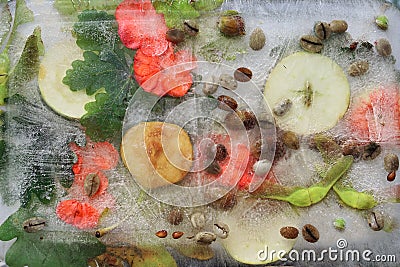 Background of black coffee beans, red small apple, flower of pelargonium and red and green leaves in ice cube Stock Photo