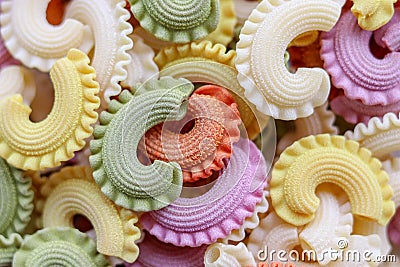 Background of colorful green, yellow, white, orange and pink italian crown pasta, close-up, top view Stock Photo