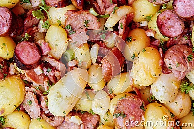 Background of cooked potato, smoked meat and sausage mix. Stock Photo