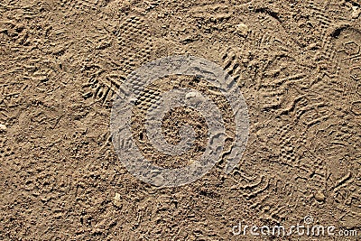 Background of the dirt ground outdoors with shoeprints on the sand under the hot sun Stock Photo