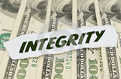 On the background of dollars lies a piece of paper with the text - INTEGRITY Stock Photo