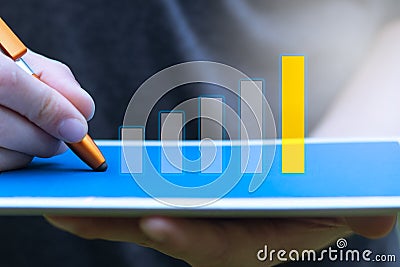 Background of financial planning and investment concept. Young man holding and writing digital tablet with graph and rows Stock Photo