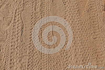 Footprints and tire treads in the sand Stock Photo