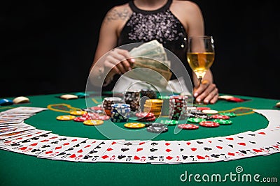 Background of a gaming casino, poker table, cards, chips and a girl with a glass of wine in the background. Background for a Stock Photo