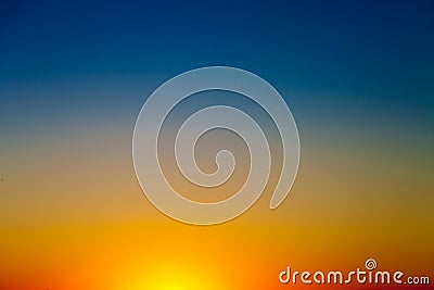 Background with gradient sunset sky in tones of yellow, orange and blue Stock Photo