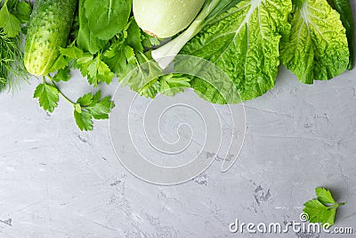 Background with green vegetables, salad, cucumber,green onion and zucchini on gray stone table top Stock Photo