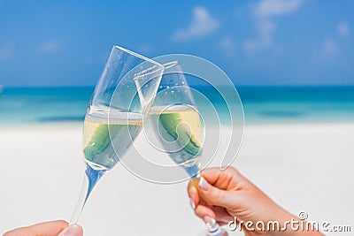 Champagne glasses in hands on beach background. Romantic honeymoon background Stock Photo