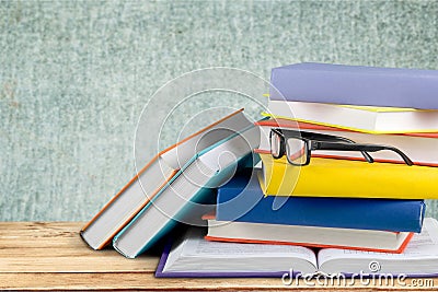 Heap of books with glasses on wooden table Stock Photo