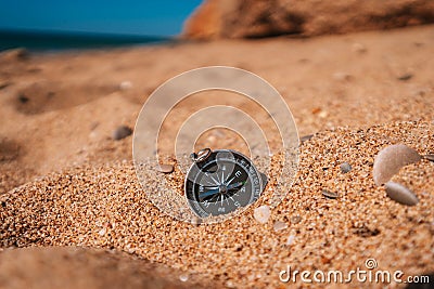 Background image of compass lying on beach with sea view, travel concept Stock Photo