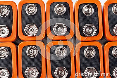 Background image of a large number of orange batteries, standing in several rows Stock Photo