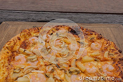 The background image is of a pizza placed on an old wooden floor. Stock Photo