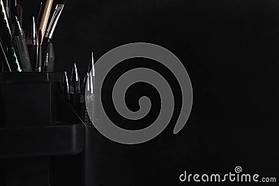 Pens and pencils in the stand. Photo on a black background Stock Photo