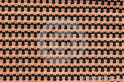 The background of a knitted fabric is orange-black with a regular geometric pattern. Openwork finely knitted woolen fabric Stock Photo