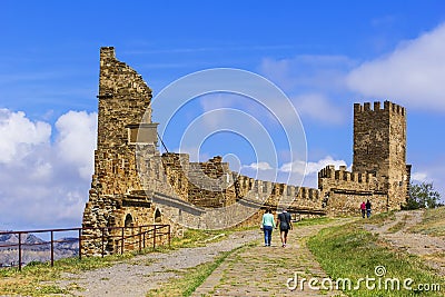 Background landscape view tourists walk in a Sudak fortress amidst the ruins of ancient towers in the Crimea Editorial Stock Photo