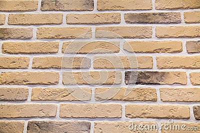 The background is made of artificial sand-colored stone with a rectangular shape in the form of a brick wall. Backgrounds, texture Stock Photo