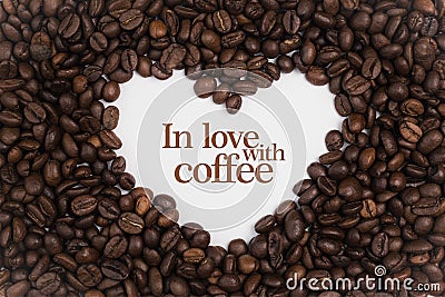 Background made of coffee beans in a heart shape with message `In love with coffee` Stock Photo