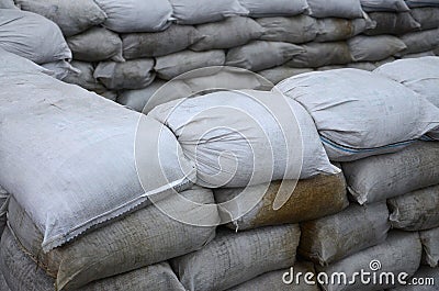 Background of many dirty sand bags for flood defense. Protective sandbag barricade for military use. Handsome tactical bunker Stock Photo