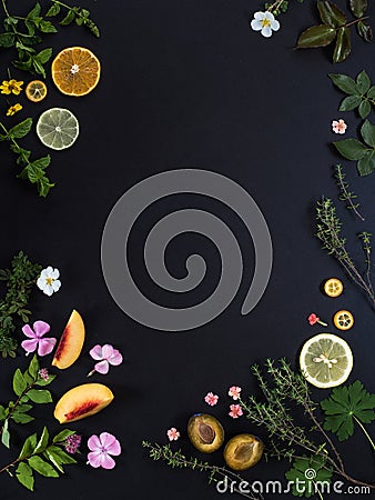 Background for the menu. Black stone background with fruits, flowers and green leaves Stock Photo
