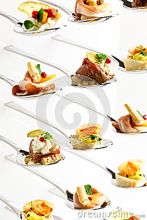 Background of mixed canapes on metal spoons. White background Stock Photo