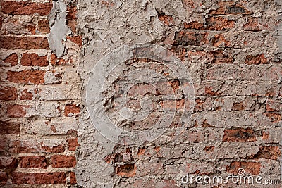 Old vintage dirty brick wall with peeling plaster, background, texture close up. Shabby building facade with damaged plaster. Stock Photo