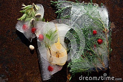 Background of red berry of hawthorn and twig of juniper frozen in ice Stock Photo