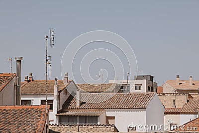 Background with spanish tiled roofs of houses against a cloudless blue sky Stock Photo