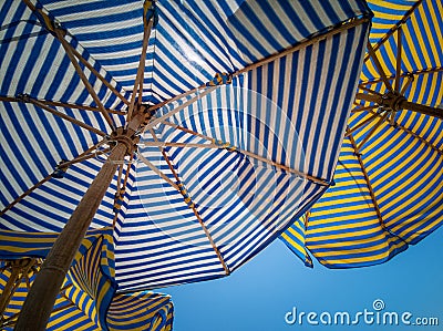 Background of striped colored beach umbrellas, view from the bottom, against the sky Stock Photo