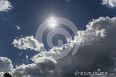 Background summer sunny bright blue sky with clouds and sun rays Stock Photo