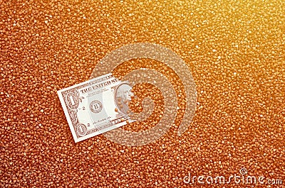 The background texture of a large pile of buckwheat, in the middle of which you see a bill of one US dollar. The concept of highe Stock Photo