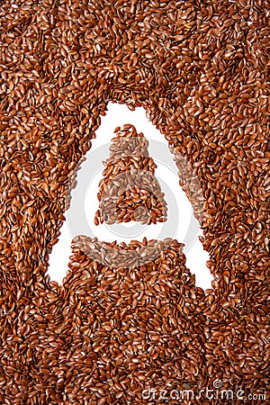 Brown seeds for healthy diet. background with texture made of of brown flax seeds with a white letter of vitamin A Stock Photo